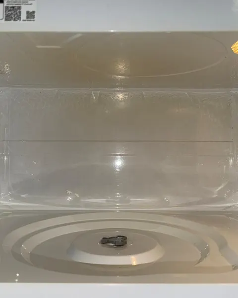 After: white microwave interior and turntable support with the glass plate removed.