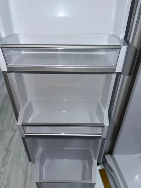 Empty white refrigerator door compartments with clear fronts.